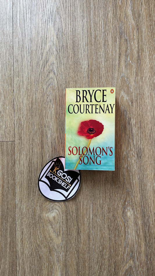 Book titled 'Solomon's Song' by Bryce Courtenay on a wooden surface with a badge.